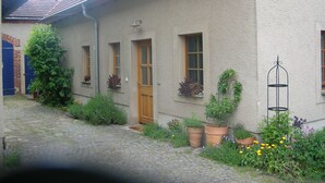 A traditional house with a cobblestone path, a wooden door, and potted plants. - Idyllically located in the center of Coswig (Coswig)