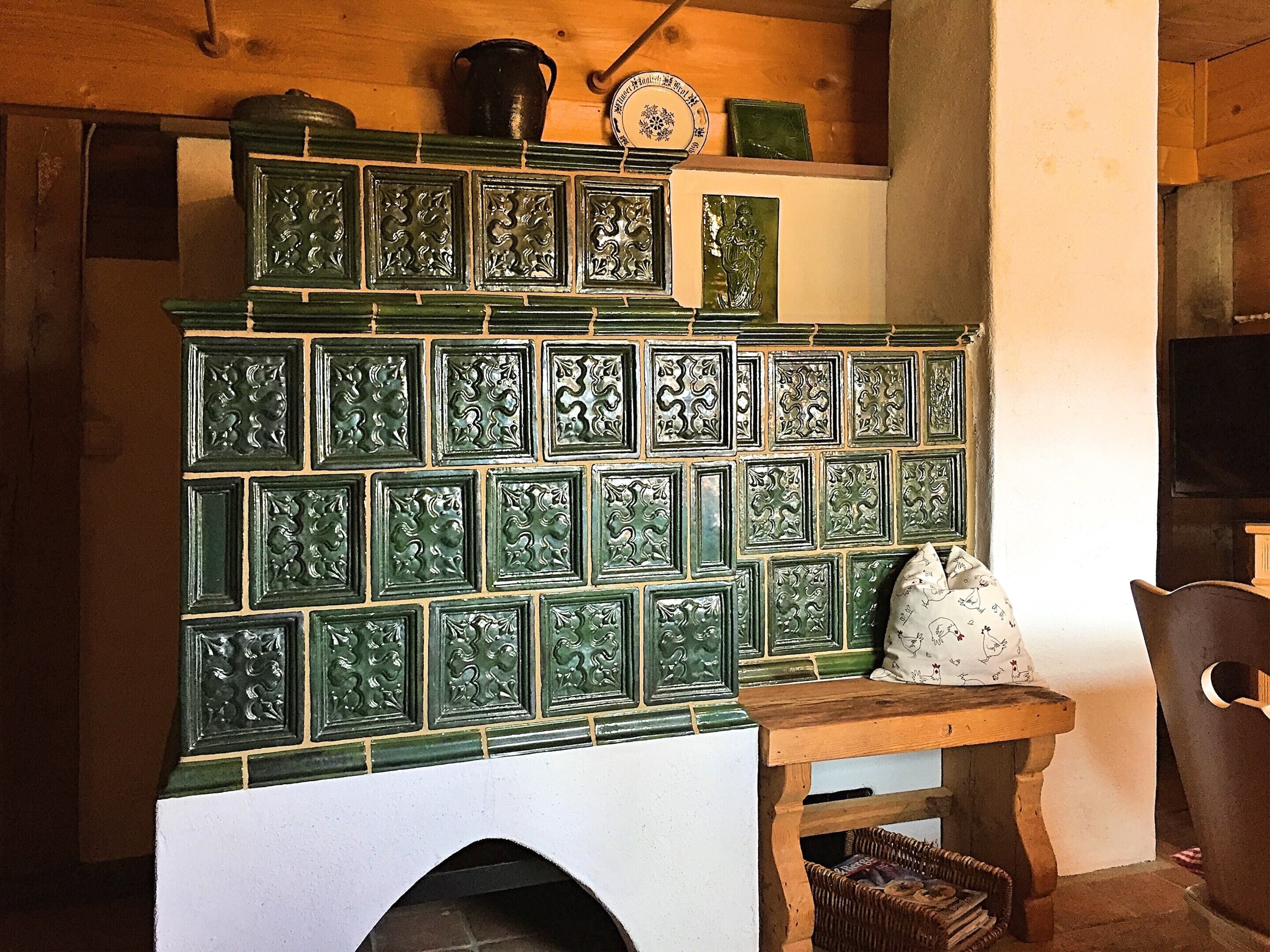 Une cheminée traditionnelle avec un manteau en faïence, une table en bois et un panier en osier.