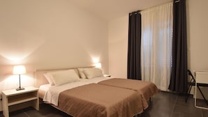 A double bed with a brown bedspread, a bedside table with a lamp, and a chair. - Spacious and Modern Apartment on the Beach in Klek (Slivno)