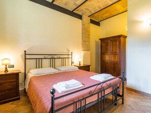 A single bed with a metal frame, two bedside tables with lamps, a wooden wardrobe, and a tiled floor. - Secluded Mansion in Perugia with Hot Tub (Perugia)