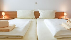 A double bed with white linens and two pillows, flanked by nightstands with lamps. - Modernes Apartment in Willingen mit Balkon (Willingen)