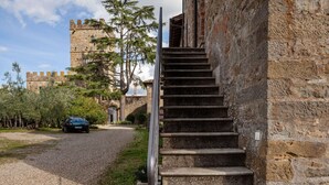 Una escalera de piedra que sube hacia un edificio, con un castillo al fondo.