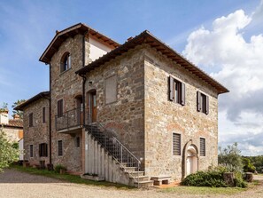 A stone building with a staircase leading to an upper level, a small balcony, and a door with a window. - Rustic Getaway in Tuscan Hills (Figline e Incisa Valdarno)