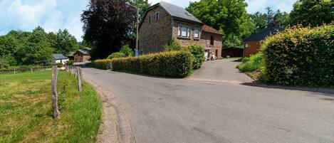 A stone house with a paved driveway leading to a garage.