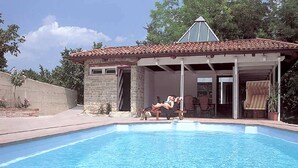A swimming pool with a stone building in the background. - Mansion in Langhe With Pool and Winery Charm (Bastia Mondovì)