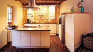 A kitchen with a central island, a built-in oven, and a refrigerator. - Mansion in Langhe With Pool and Winery Charm (Bastia Mondovì)
