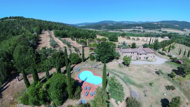 An aerial view of a property with a swimming pool, a stone building, and surrounding greenery. - Apartment in a Rustic House in the Tuscan Hills Near the Sea (Monterotondo Marittimo)