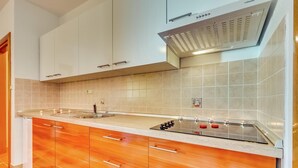 A modern kitchen with white cabinets, a stainless steel stove, and a tiled backsplash. - Serene Apartment in Dramalj with Hot Tub (Crikvenica)