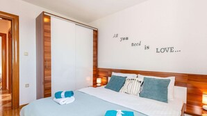 A hotel room with a bed, a wall with a motivational quote, and a wooden wardrobe. - Luxurious Apartment in Kvarner by Sea (Crikvenica)