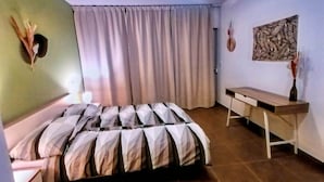 A bedroom with a bed, a desk, a curtain, and a wall-mounted decoration. - Apartment by the Beach in Dalmatia (Bilice)