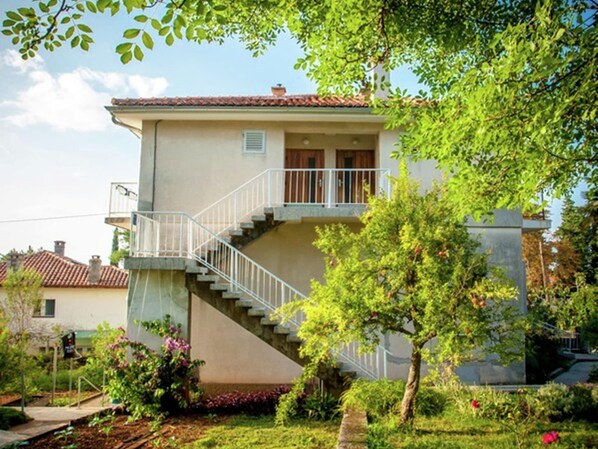 A two-story house with a balcony and a staircase leading to the upper floor. - Cosy Apartment in Malinska With Barbecue (Malinska-Dubasnica)