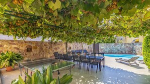 Eine Außenpatio mit einem Tischtennistisch, Stühlen und einem Poolbereich.