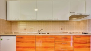 A kitchen with white cabinets, a sink, and a stove. - Alluring Apartment in Dramalj with Hot Tub (Crikvenica)