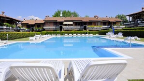 A swimming pool with lounge chairs, a clear sky, and buildings with tiled roofs. - Vibrant Holiday Home in Lazise with Swimming Pool near 2 Lakes (Lazise)