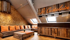 A cozy, rustic interior with a stone wall, wooden furniture, and a sign reading "Le Castelain". - Group Villa With Pool & Sauna (Florenville)