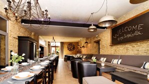 A restaurant with a long dining table, multiple seating options, and a 'Welcome' sign on the wall. - Group Villa With Pool & Sauna (Florenville)