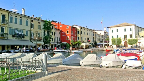A waterfront area with buildings, a canal, and boats.