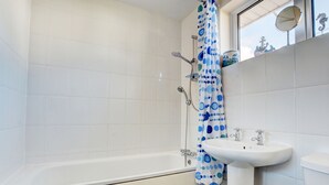 Een bad/douchecombinatie, handdoeken