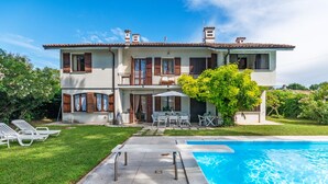 A two-story house with a swimming pool, outdoor furniture, and a garden. - Spacious Lake Garda Villa With Private Pool, Garden and Direct Lake Access (Lazise)