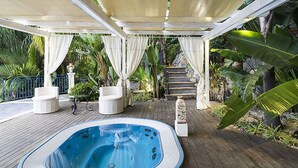 A covered outdoor area with a hot tub, seating, and a staircase leading to an upper level. - Exclusive Villa With Panoramic Swimming Pool and Hot Tub, Near the Sea (Letojanni)