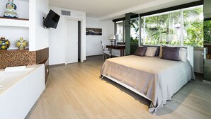 A modern bedroom with a large bed, a desk, and a TV mounted on the wall. - Exclusive Villa With Panoramic Swimming Pool and Hot Tub, Near the Sea (Letojanni)