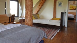 A bedroom with a loft bed, a desk with a lamp, a chair, and a bed with a blanket. - Ferienwohnung Parkblick mit 3 Schlafzimmern (Niepars)