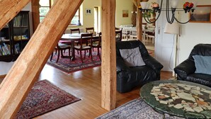 A spacious loft with exposed wooden beams, a dining area, and leather sofas. - Ferienwohnung Parkblick mit 3 Schlafzimmern (Niepars)