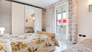 A bedroom with a bed, a wardrobe, a chair, and a window with curtains. - Vibrant Holiday Home in Lazise with Swimming Pool near Lake (Lazise)