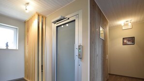 Ein modernes Interieur mit einer Schiebetür, Holzvertäfelung und einem gerahmten Bild an der Wand.