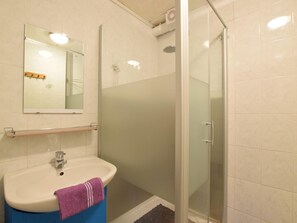 A bathroom with a sink, mirror, and glass shower enclosure. - Cottage in a Well-equipped and Comfortable Farmhouse (Marche-en-Famenne)