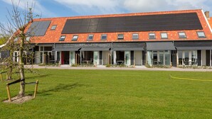 A modern building with a flat roof, solar panels, and a well-maintained lawn. - Scenic Holiday Home in Oostkapelle near Beach (Oostkapelle)