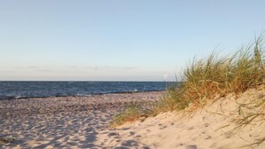 A sandy beach with waves and sparse vegetation. - Gemutliche Ferienwohnung in Satow (Satow)