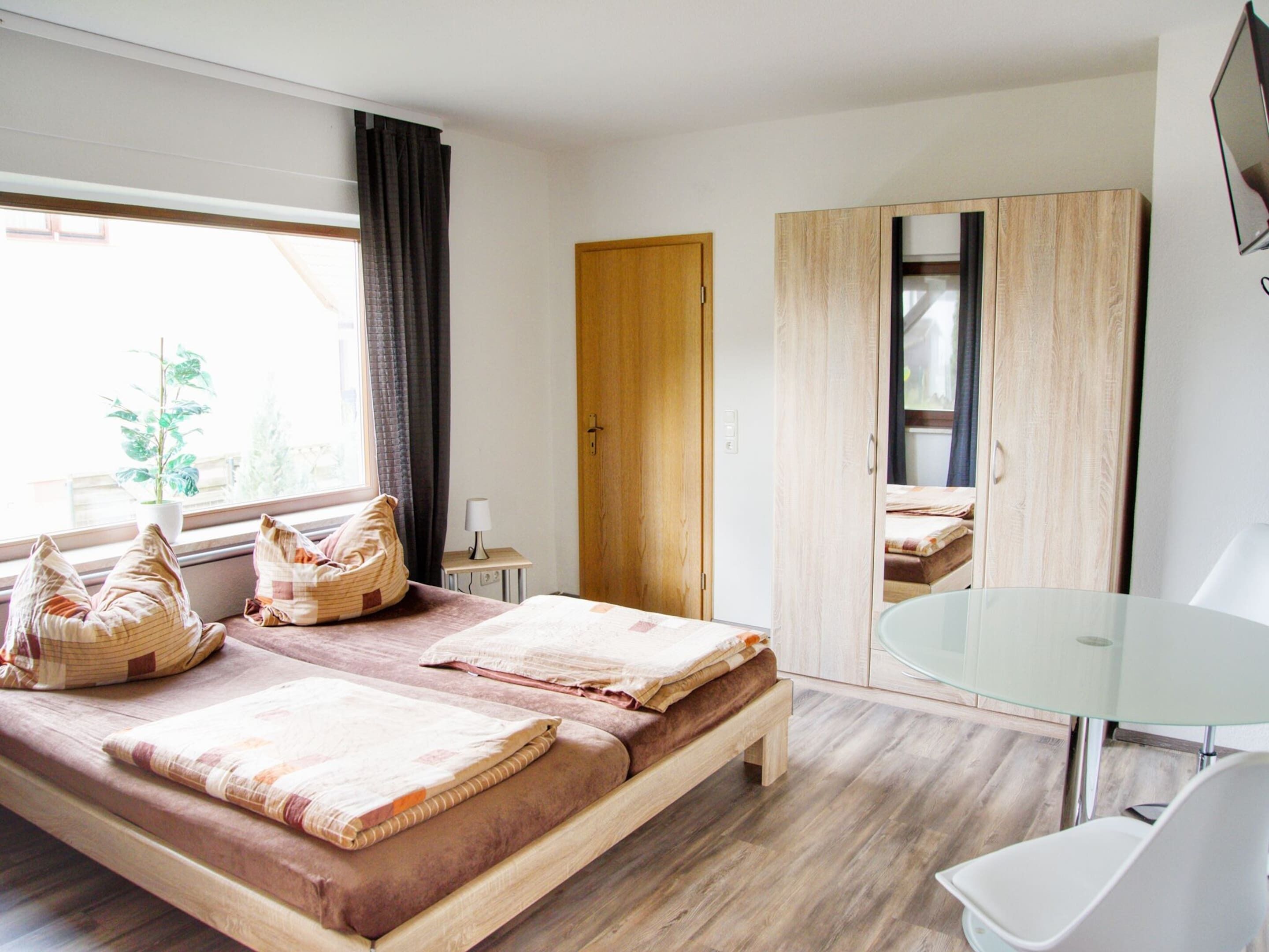 A modern room with a bed, a desk, and a wardrobe.