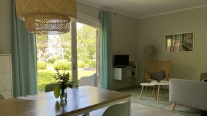A modern living room with a dining table, chairs, a television, and a sofa. - Apartment Near Saaler Bodden Lagoon (Saal)