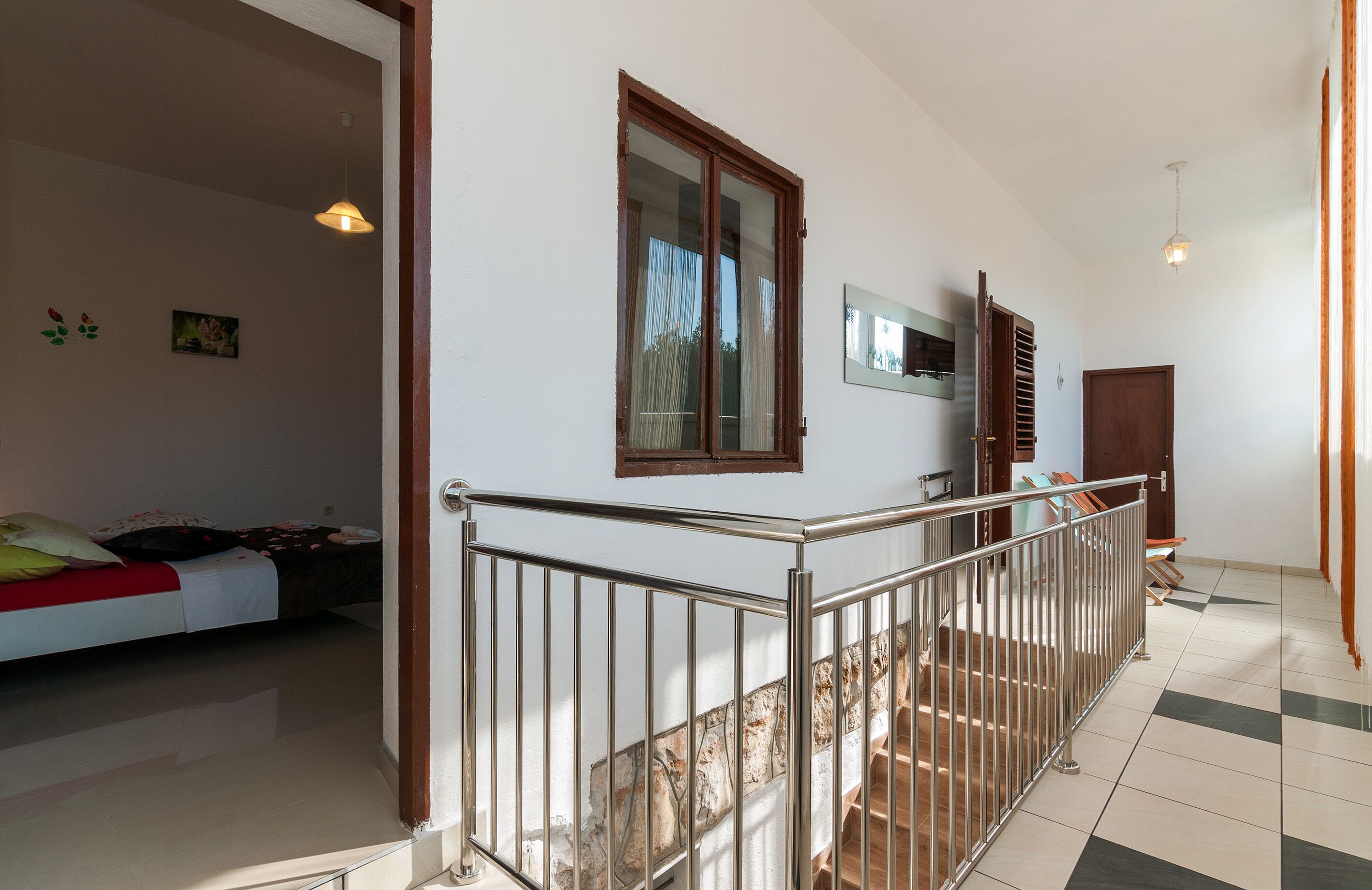 Ein geräumiges Zimmer mit einem Bett, einem Fenster und einer Treppe, die zu einer anderen Ebene führt.