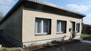 A single-story brick house with two large windows and a small porch. - Spacious Bungalow near Sea in Grundshagen (Klütz)