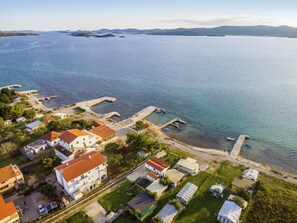 A coastal residential area with houses, a pier, and boats.