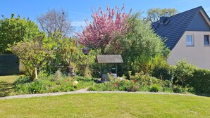A residential garden with a variety of plants and a birdbath. - Romantic Retreat in Kropelin (Kroepelin)