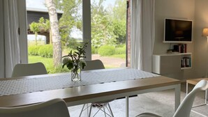 Ein moderner Essbereich mit Tisch, Stühlen und einem Blumenstrauß.