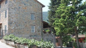 A stone building with two windows and a balcony. - Modern Villa With Private Pool and Fenced Garden Near Lucca (Capannori)