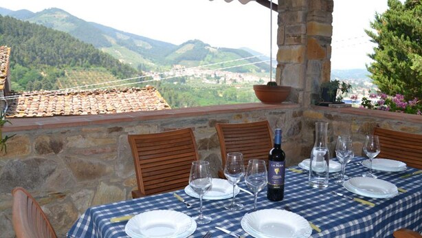 A table set for dining with a view of a mountainous landscape. - Modern Villa With Private Pool and Fenced Garden Near Lucca (Capannori)