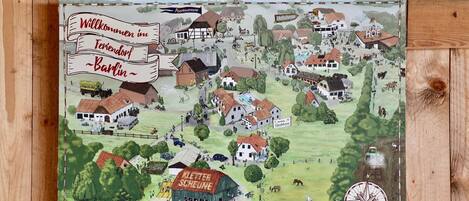 A detailed map of a village with various buildings, including houses, a barn, and a swimming pool.