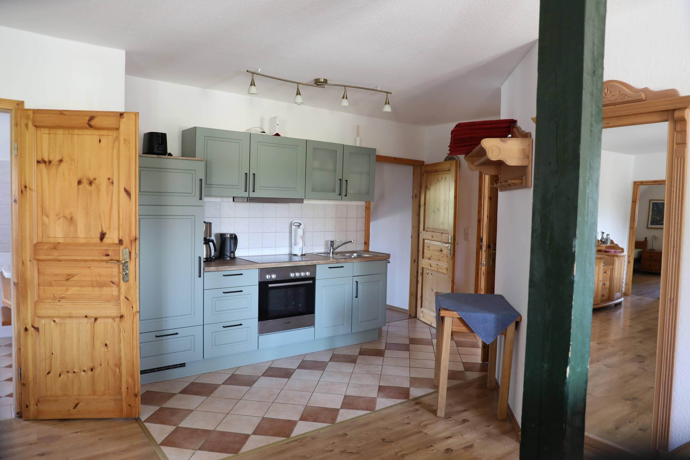 A kitchen with light blue cabinets, a stove, and a sink.