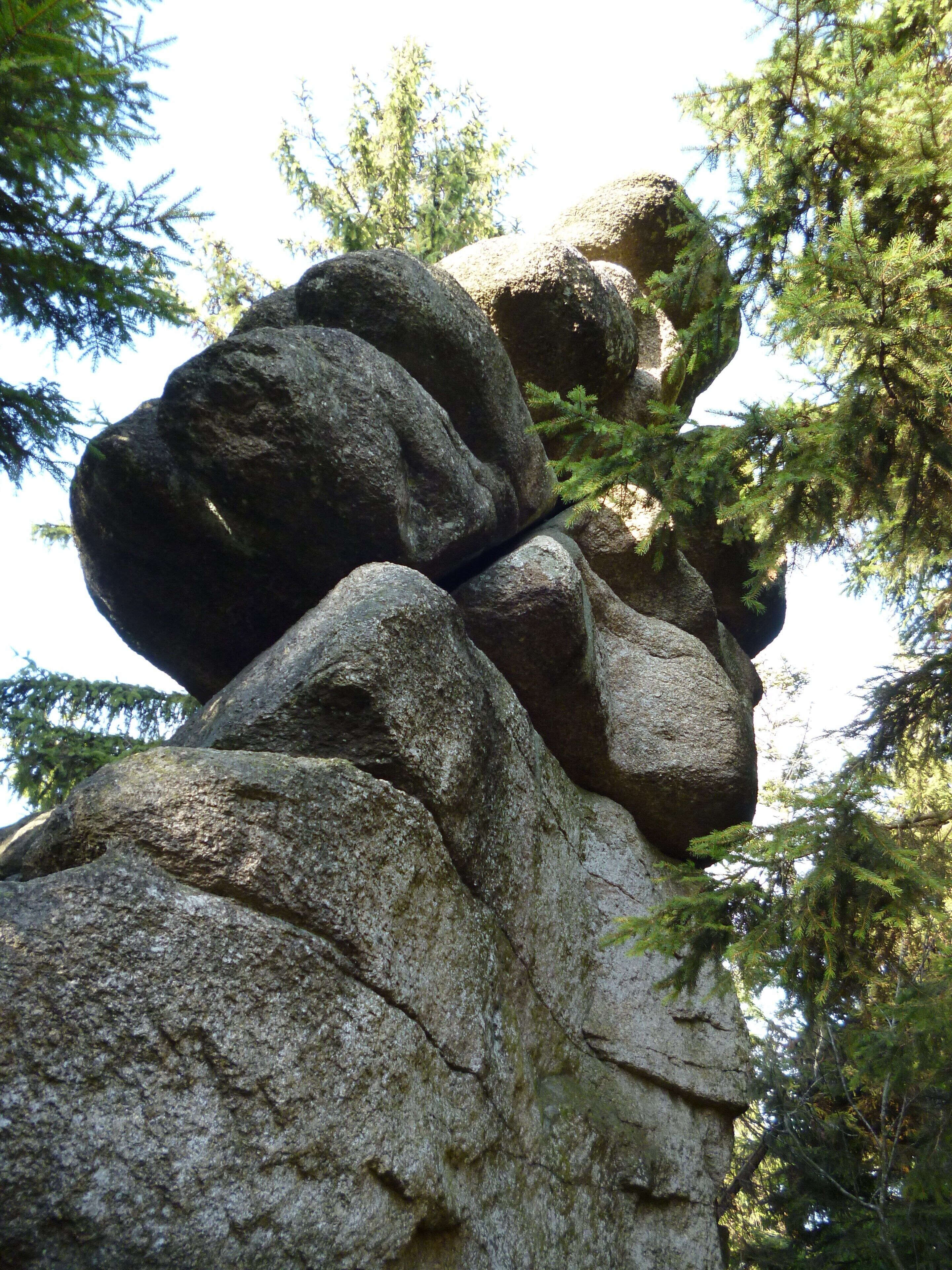 A large rock formation surrounded by trees.