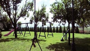 Un parque con columpios y un tobogán.