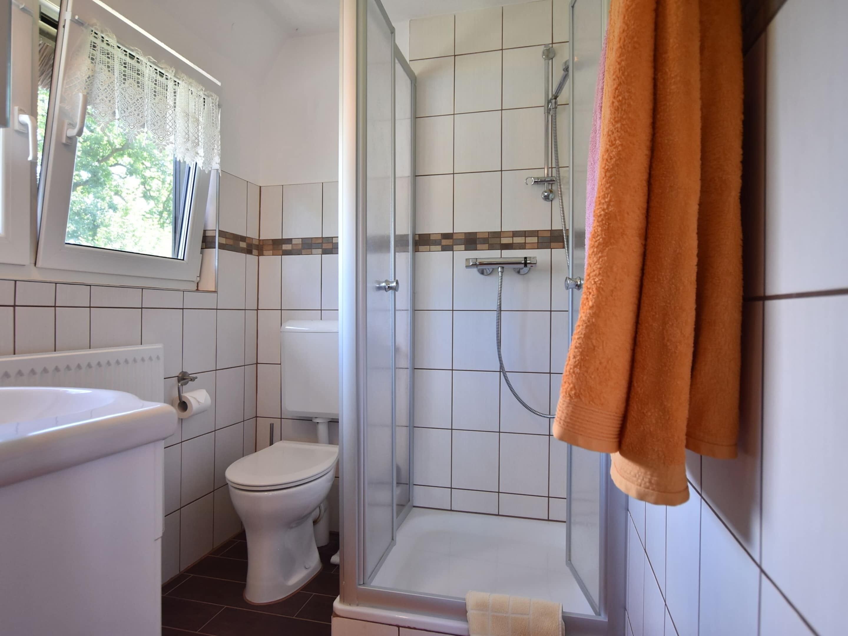 Un baño con inodoro, lavamanos y ducha.