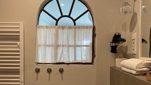 A bathroom with a window, towel rack, and a towel on the counter. - Grosszuegige Ferienwohnung mit Garten (Saal)