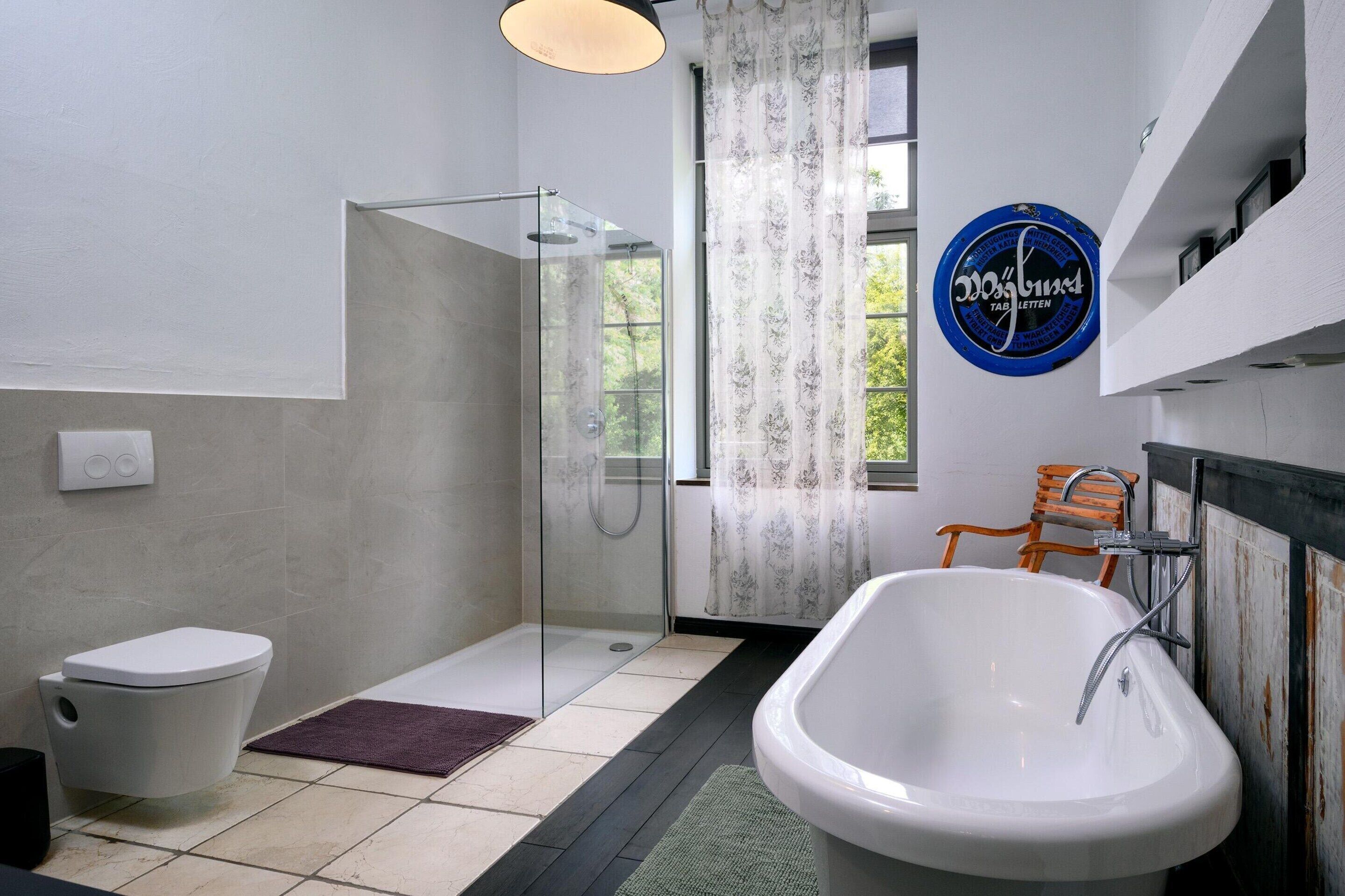 Un baño con ducha envuelta en cristal, inodoro y bañera.