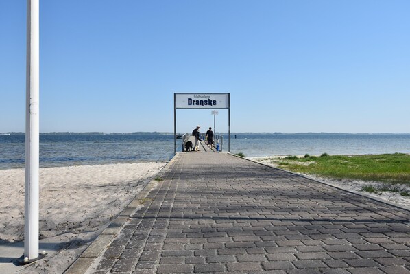 A paved walkway leading to a body of water with a sign reading "Dranske." - Sunny Apartment in Wiek, Rugen (Wiek)