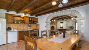Una cucina rustica con travi in legno, un arco in pietra e un tavolo con sedie.
